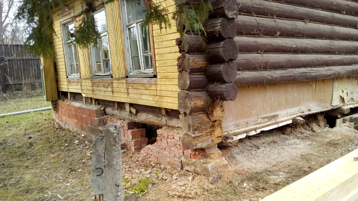 Гниение нижних венцов у бревенчатого дома — вид до ремонта Сгнивший угол нижнего венца и разрушенный кирпичный цоколь — нужна замена обвязки